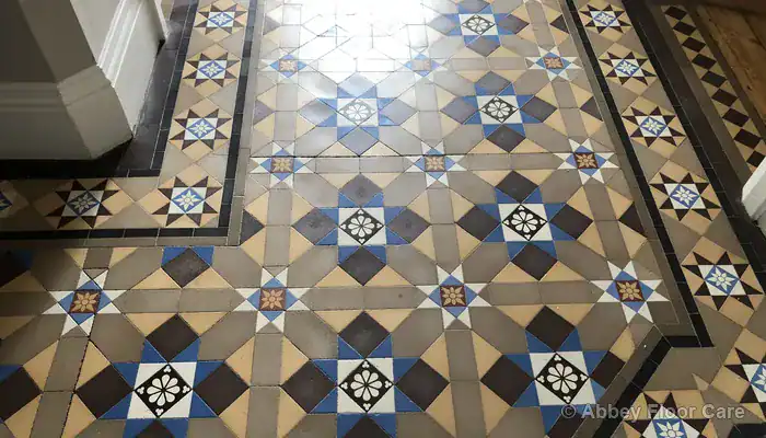 Victorian hallway tiles showing dished traffic wear and dull clay surface in walking paths
