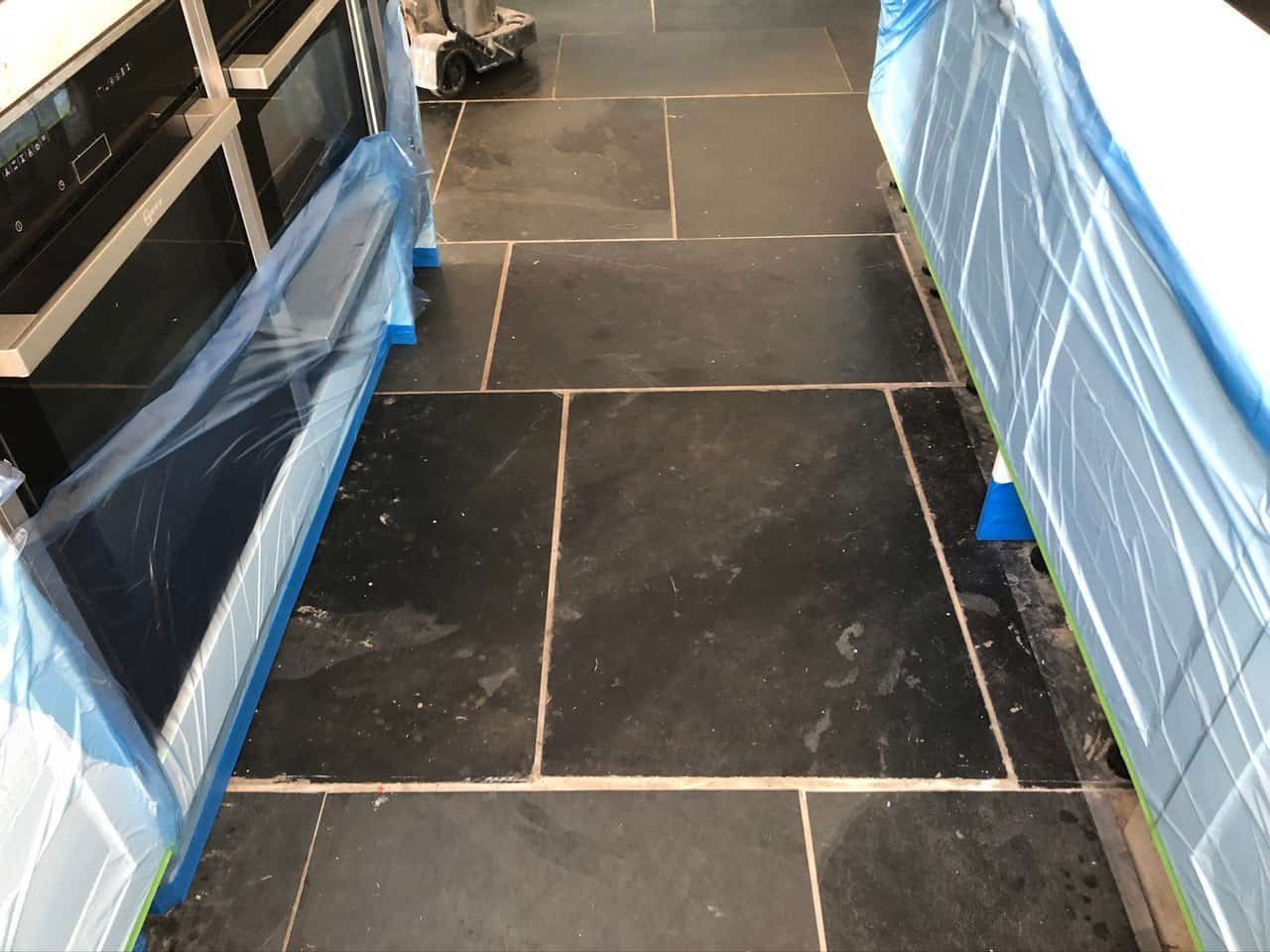 Slate floor tiles with heavy soil build-up along the grout joints